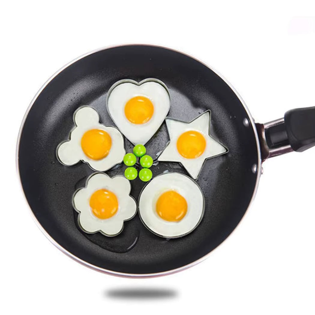 Small non-stick frying pan cooking eggs for quick breakfast
